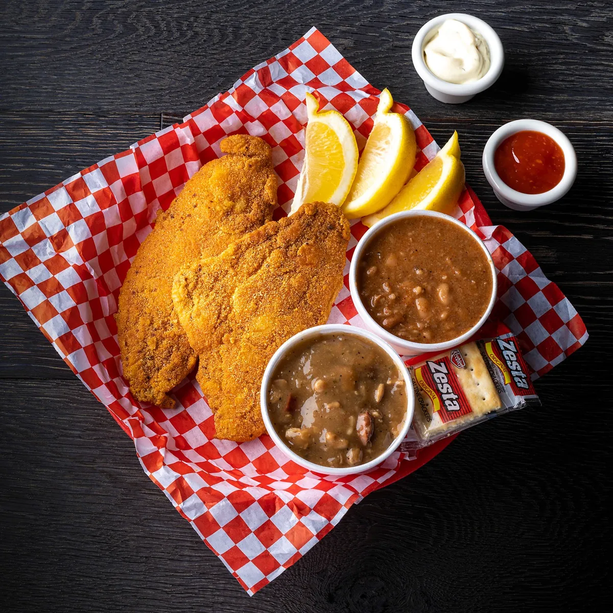 Two fried catfish fillets with gumbo and red beans and rice